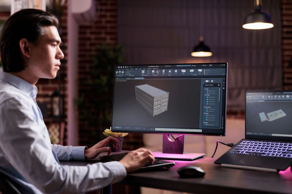 A man is working with a 3D model at his computer