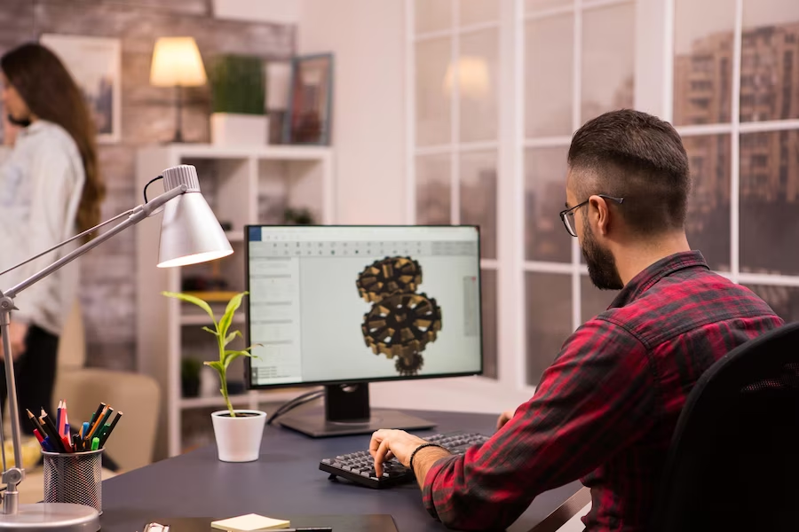 Man with glasses working on a 3D project on a computer