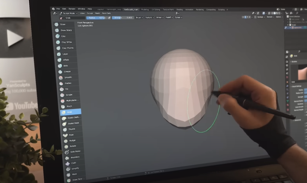 Hand using pen and touchscreen to create a 3D character